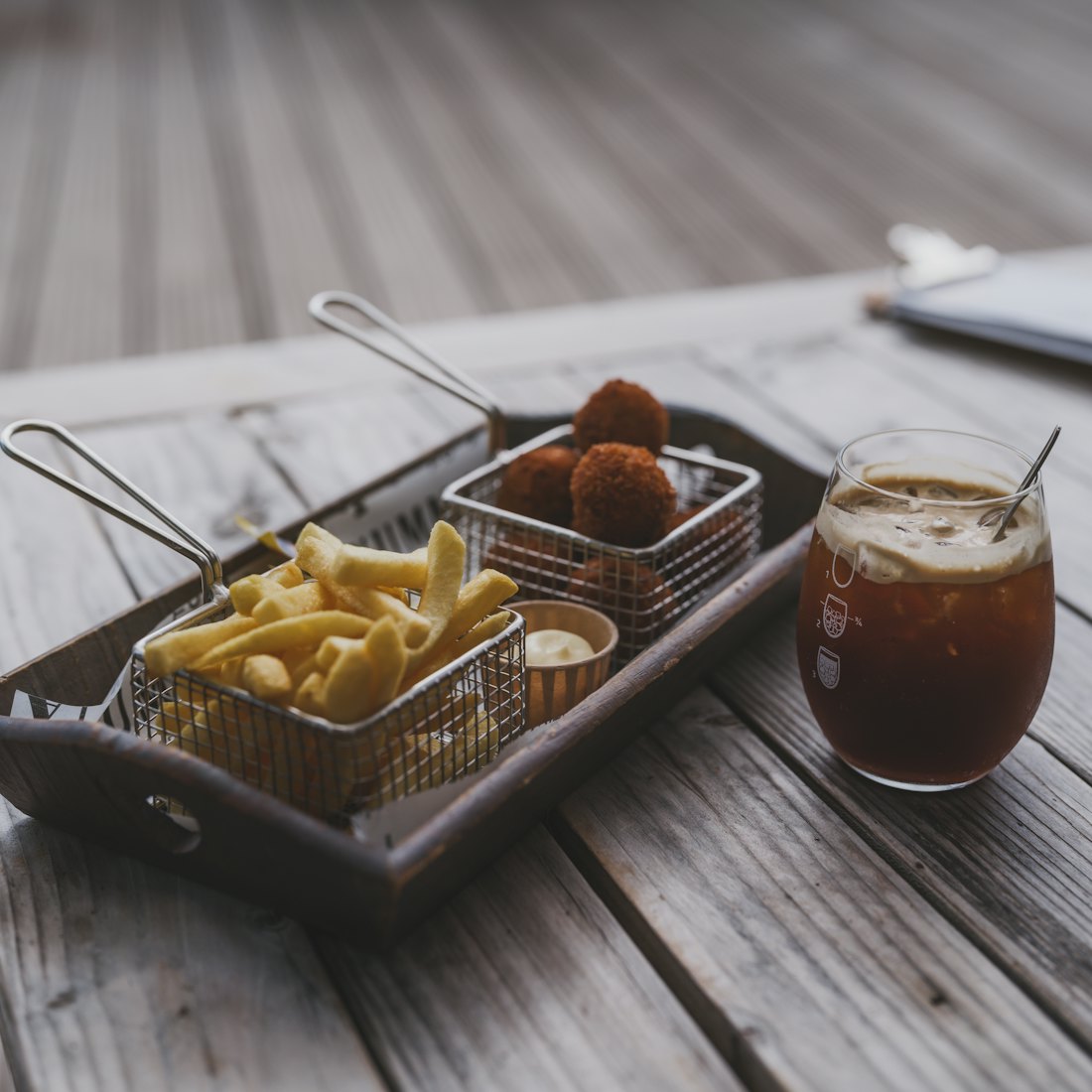 French fries and fried balls with dipping sauce and drink