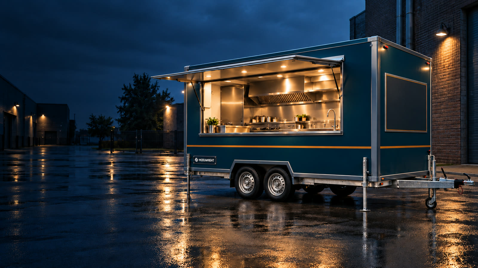 Design visualisation of a twin-axle mobile kitchen
      trailer at dusk in a wet service yard, service hatch raised on gas struts, stainless work line and extraction
      canopy lit inside, corner steadies down and the drawbar and coupling visible