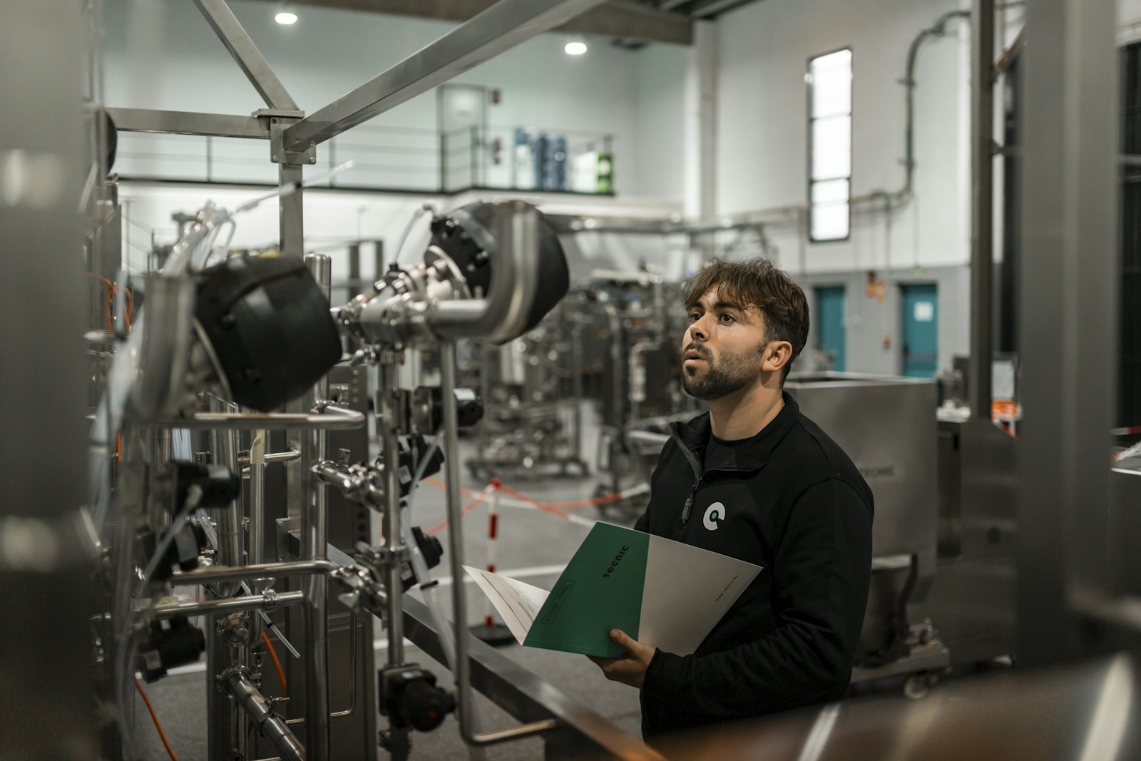 A man inspects machinery in a factory