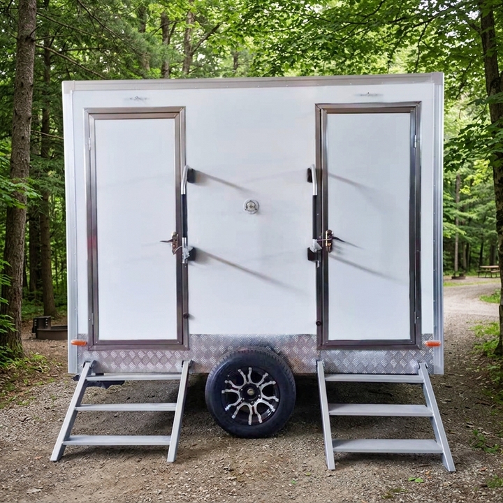 Twin axle site cabin with two entrance doors, photographed on open ground.